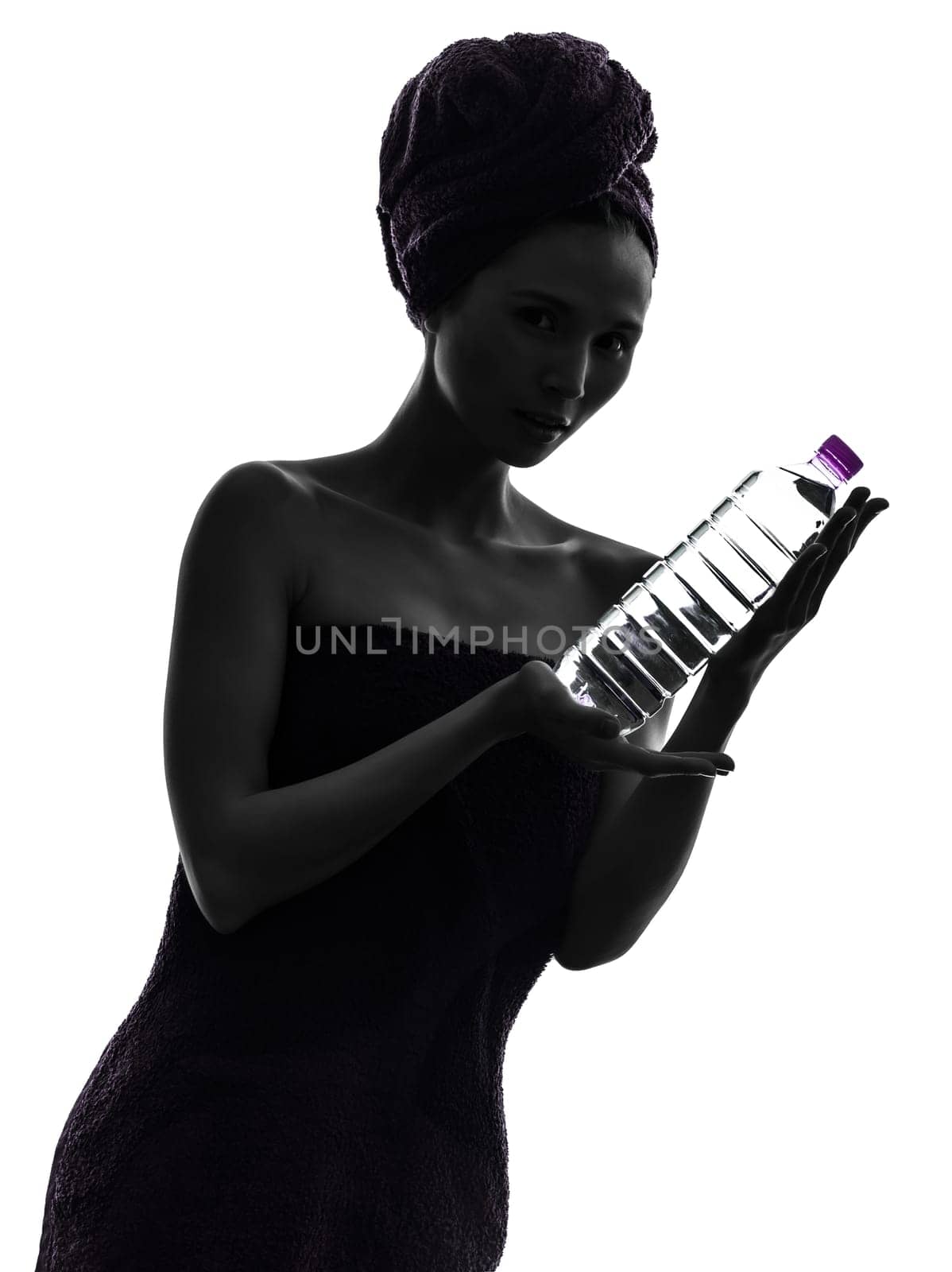 one beautiful asian young woman wrapped towel holding bottle water  in silhouette studio isolated on white background