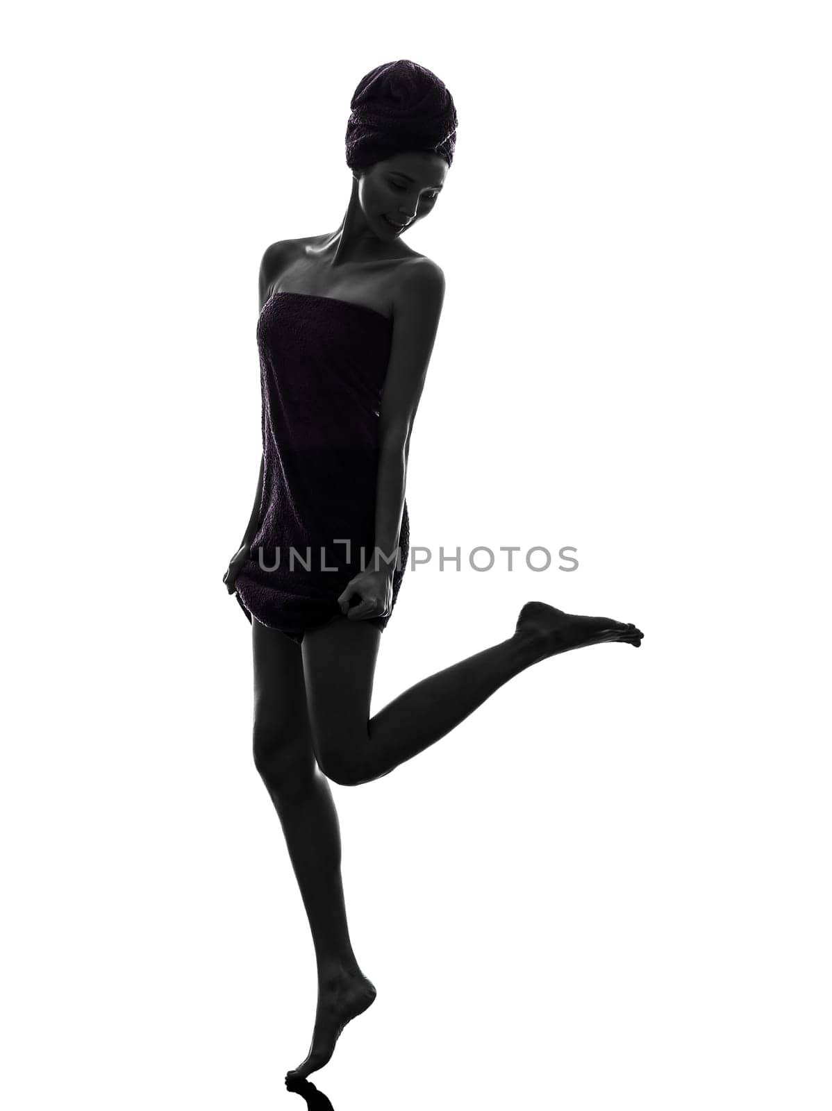 one beautiful asian young woman looking at her legs wrapped towel in silhouette studio isolated on white background