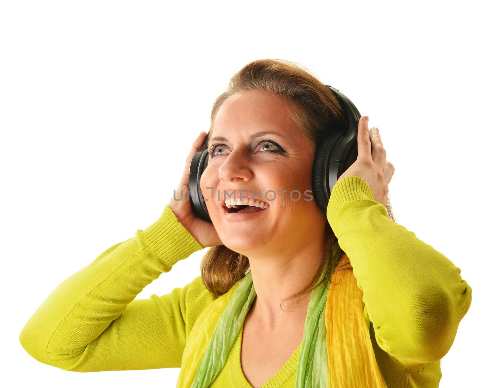 Happy young woman listening to the music in headphones isolated on white background