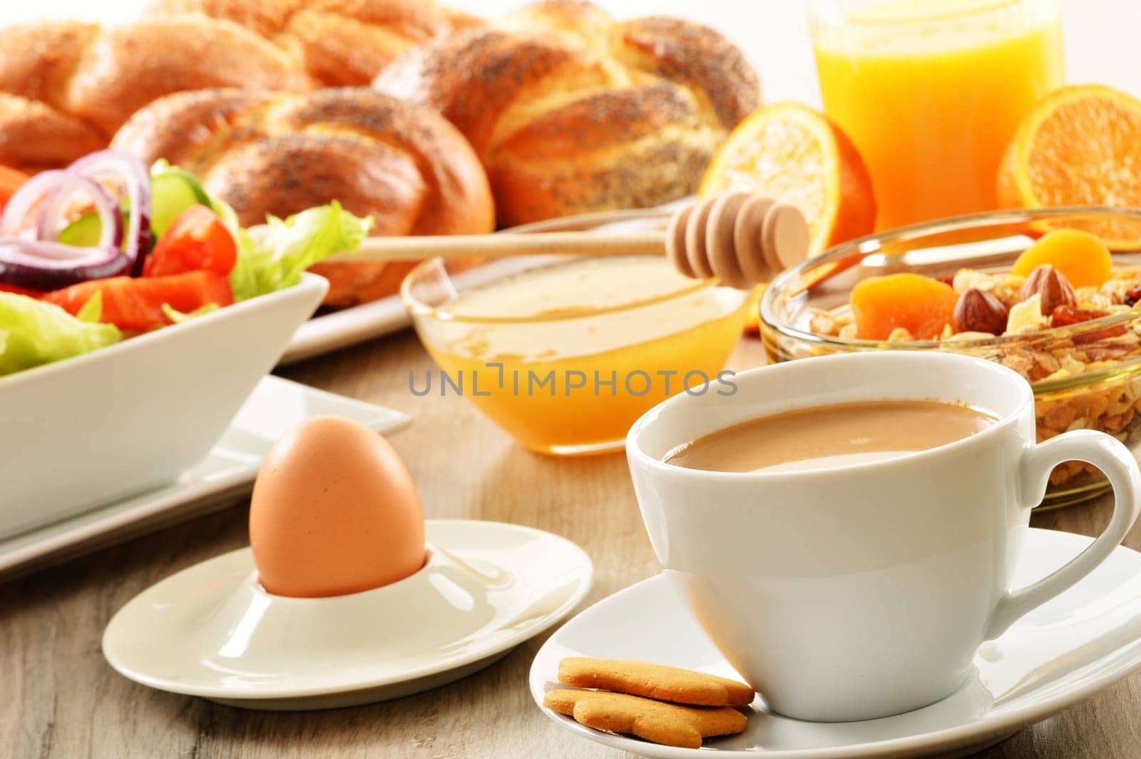 Breakfast including coffee, bread, honey, orange juice, muesli and fruits