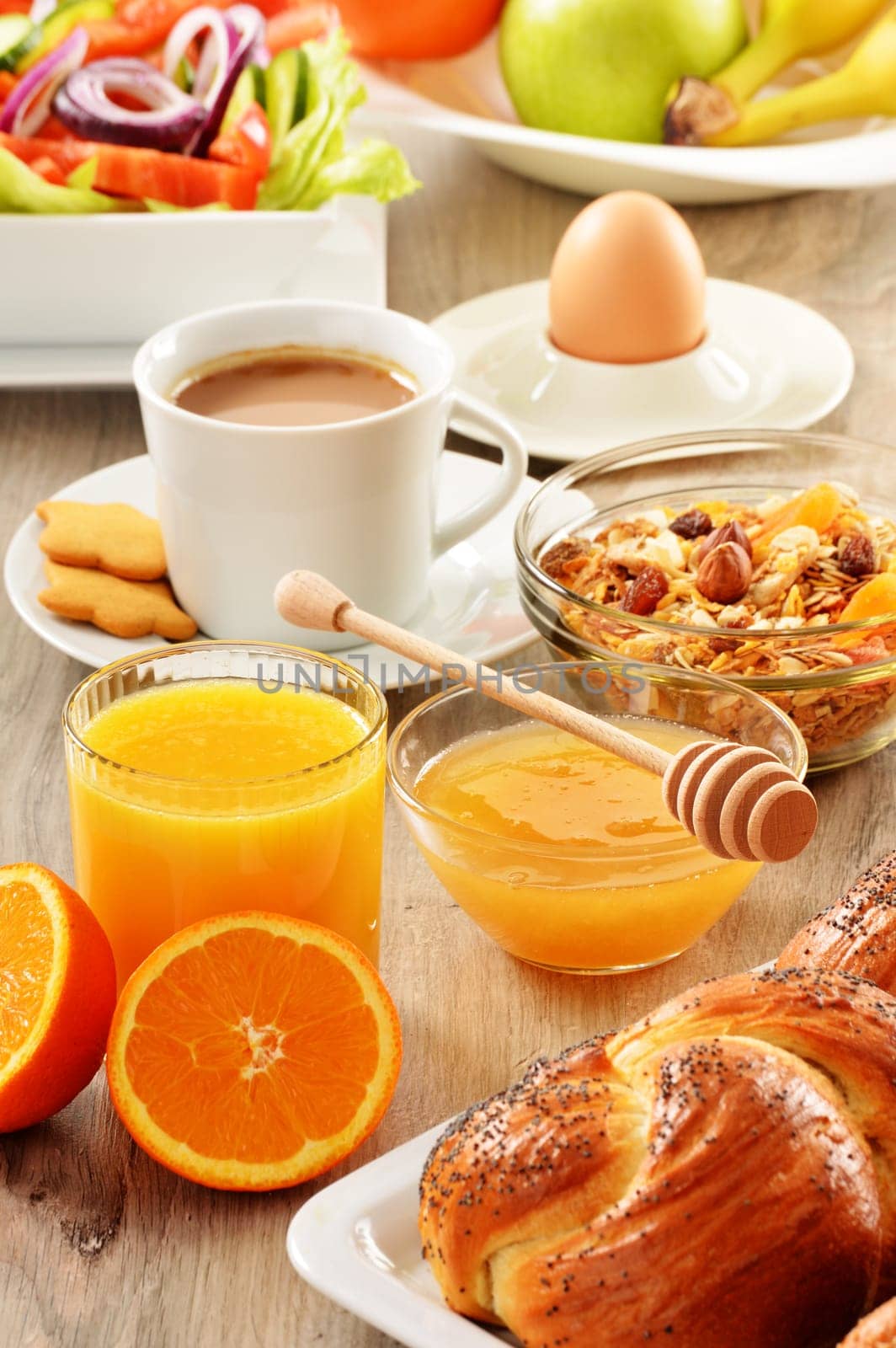 Breakfast including coffee, bread, honey, orange juice, muesli and fruits