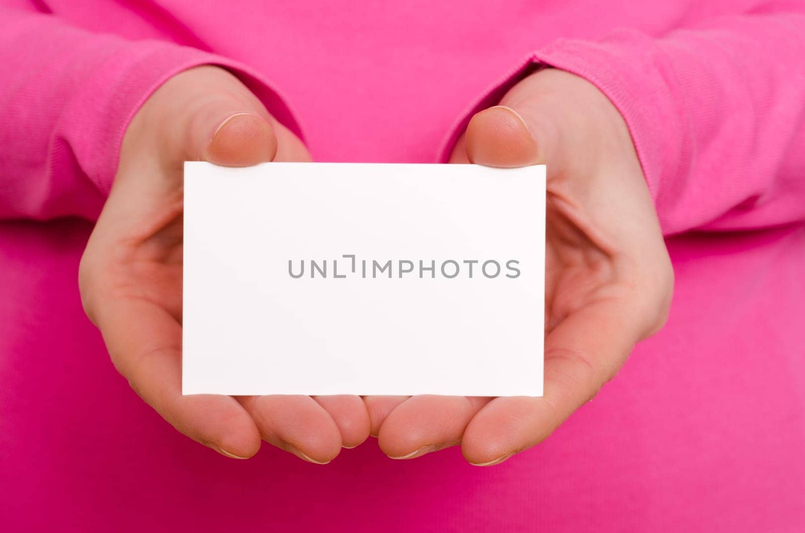 Two female hands holding a blank business card