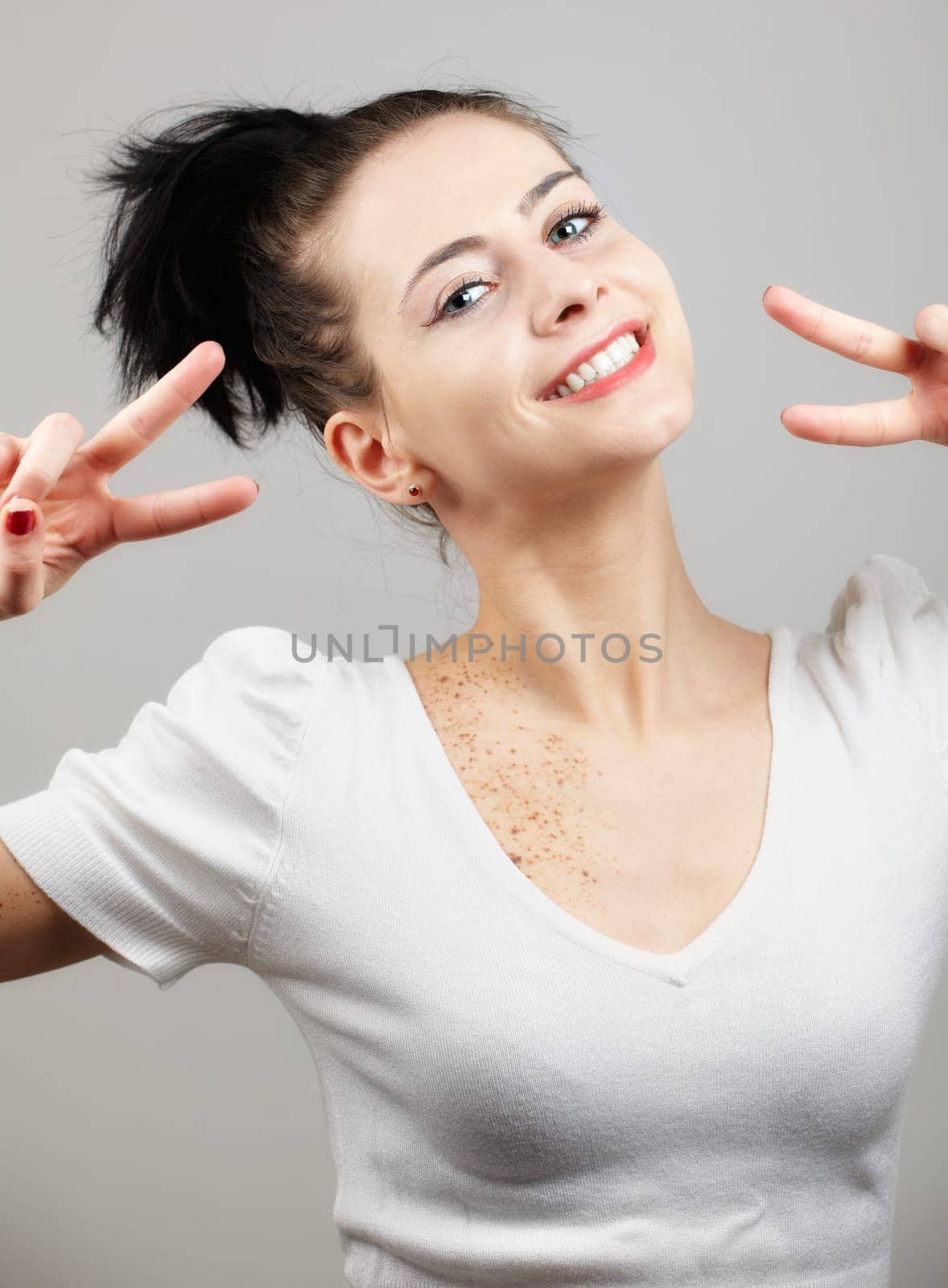 Portrait of a beautiful young woman smiling isolated on grey