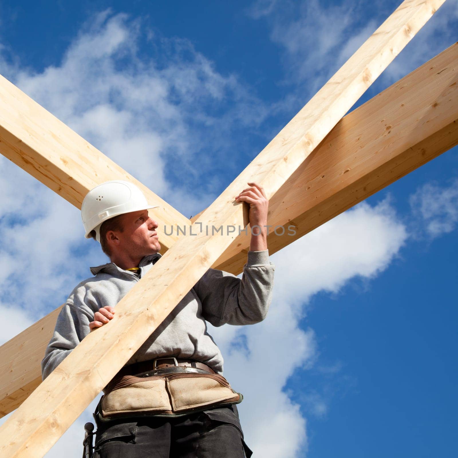 carpenter at work with wooden  roof construction