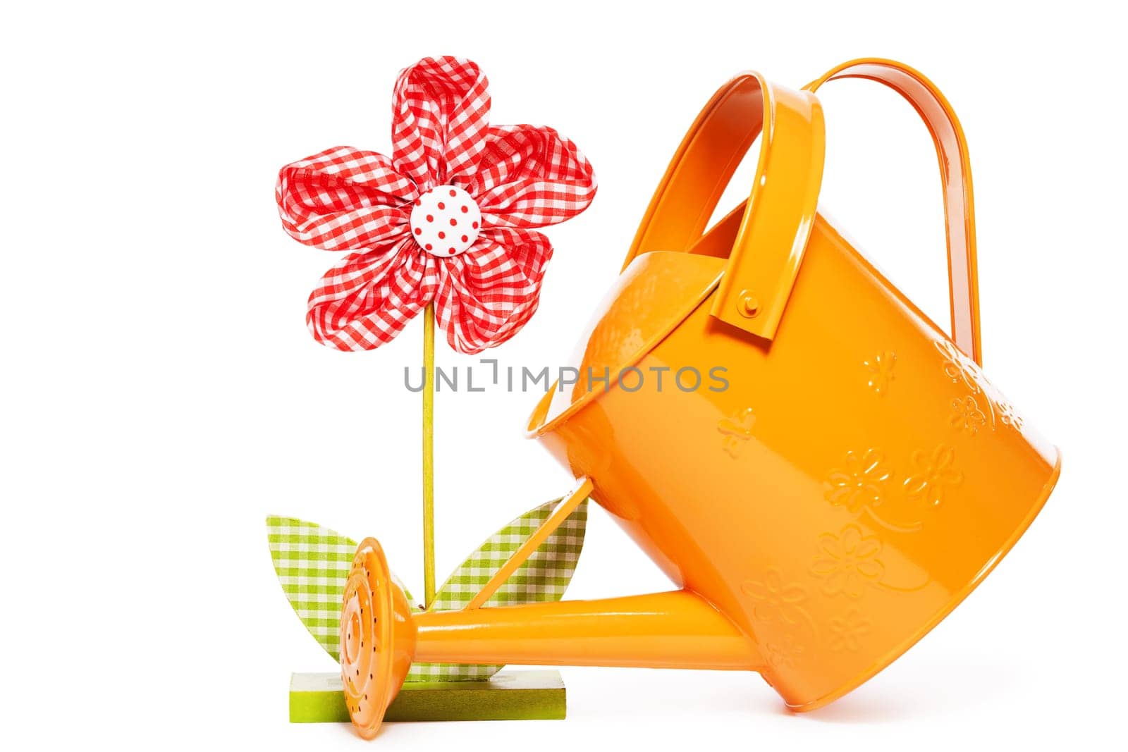 Red fabric flower with orange watering can on white background