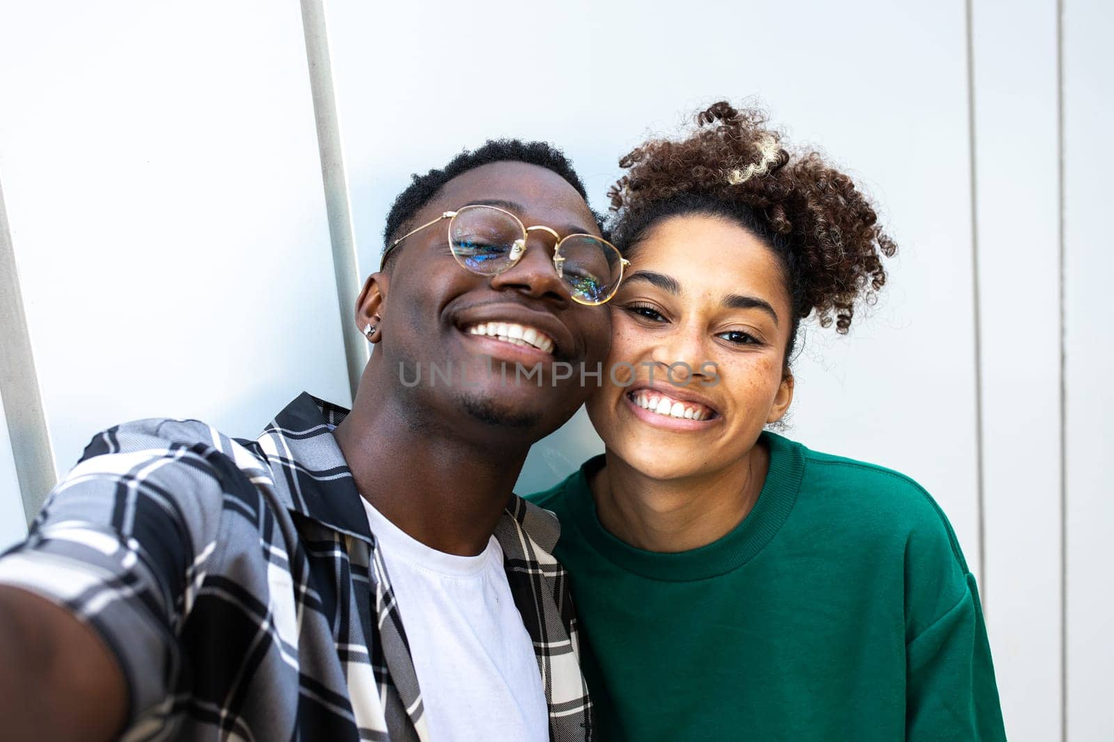 Happy African American young couple taking selfie looking at camera. Relationship and love concept.