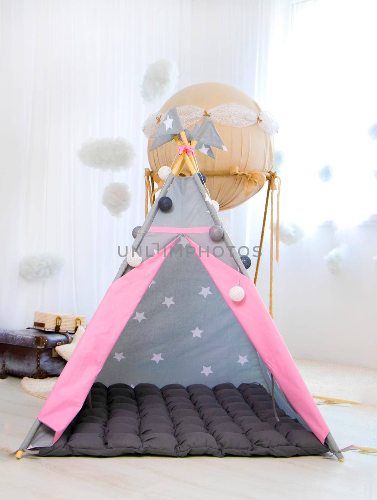 Playroom with Teepee. Modern room interior with play tent for child. pink children's wigwam in the room on the floor Scandinavian style with decor. High quality photo