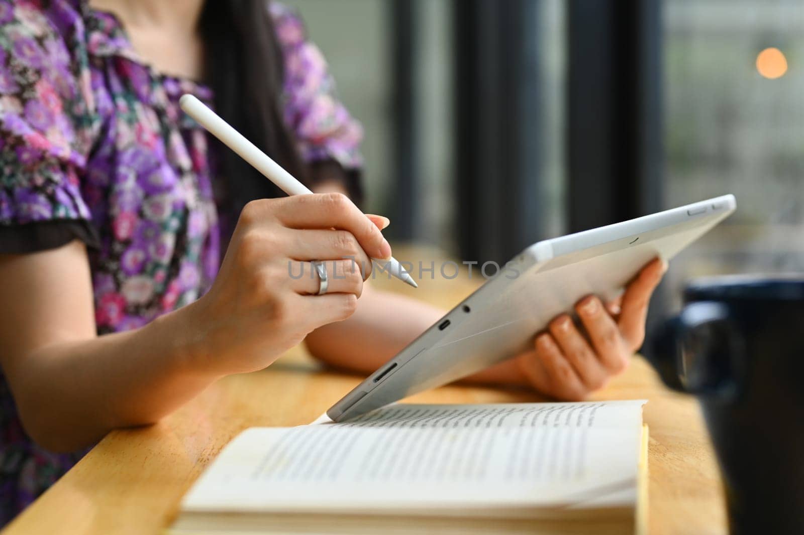 Select on woman hand holding stylus pen and writing notes on digital tablet. People, technology and lifestyle.
