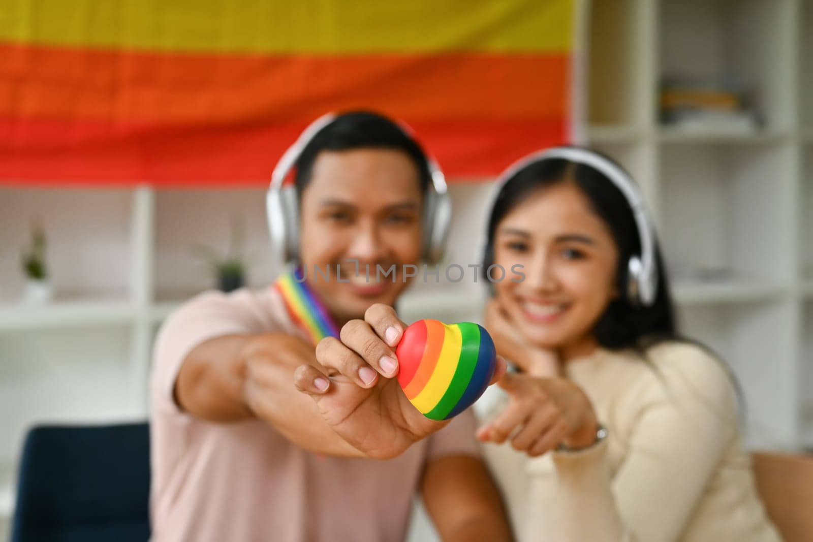 Male and female hands holding rainbow heart to camera. LGBTQ, human rights and equality social by prathanchorruangsak