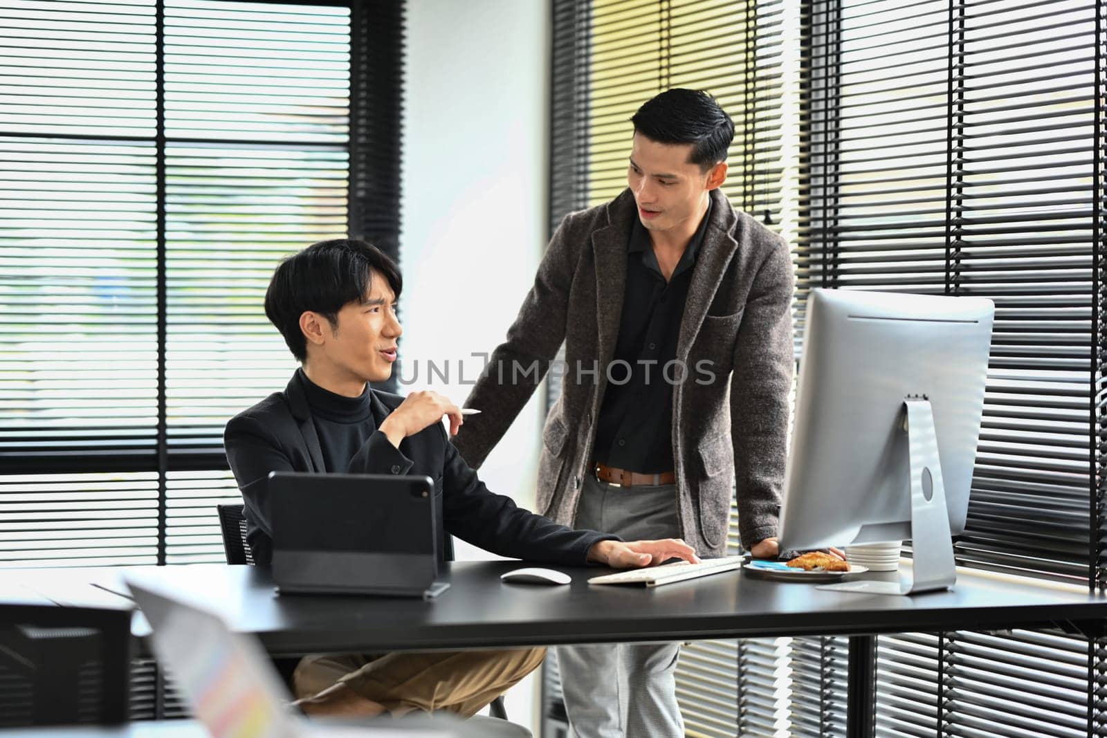 Two professional business people working on financial market data at modern office.