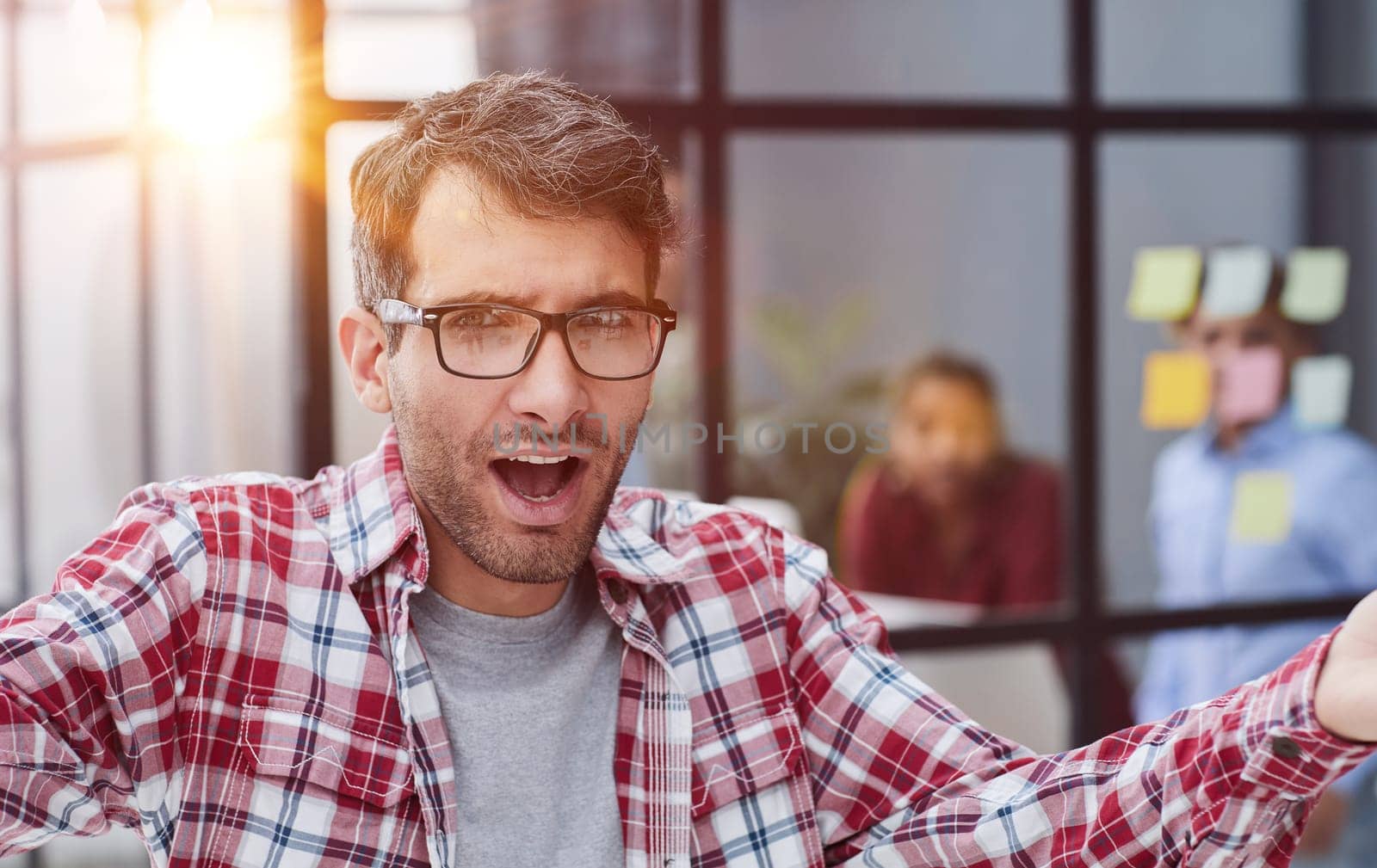 Portrait young man wearing smart casual shirt in modern coworking space