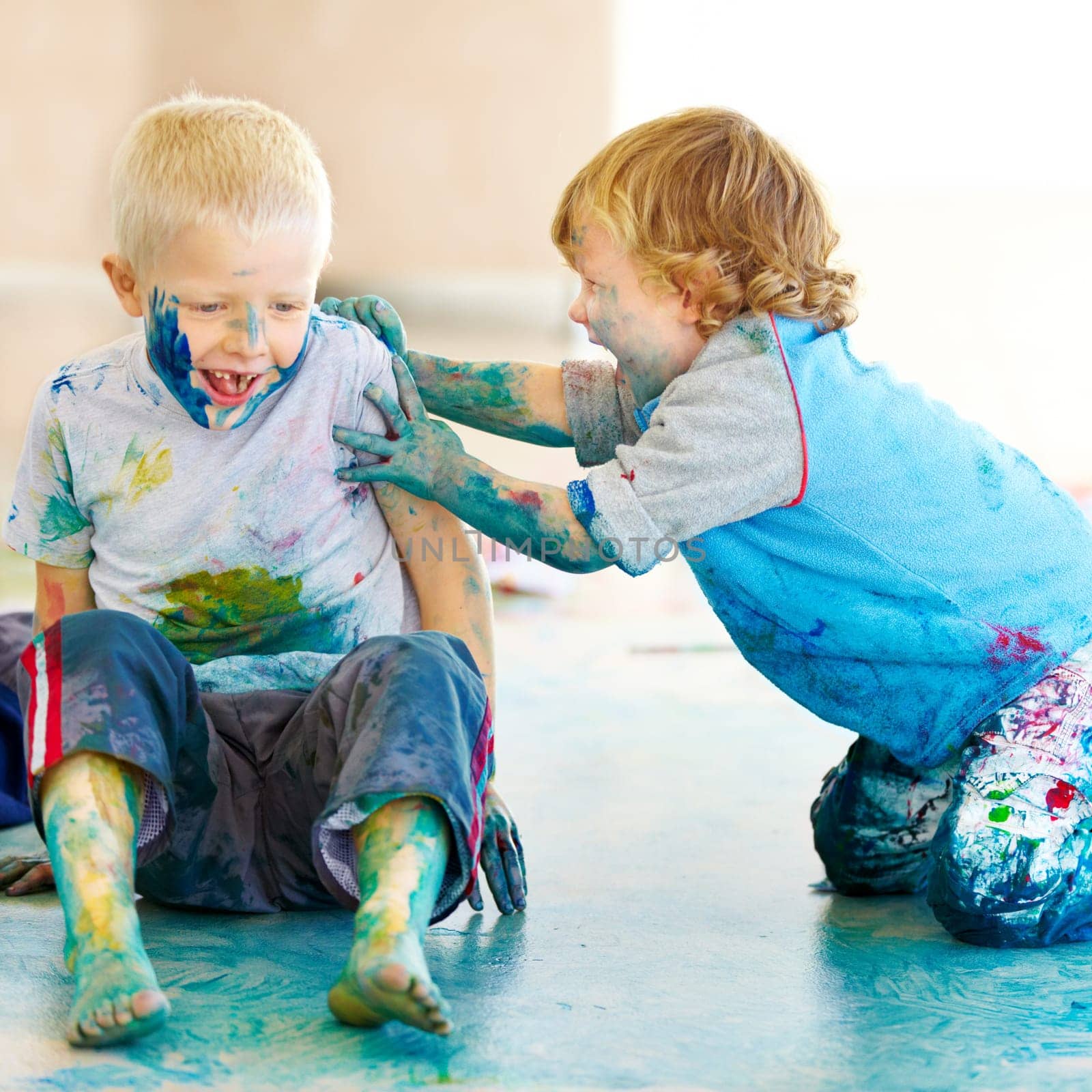 Friends, smile and children painting on the floor of a studio for creative expression or education at school. Art, paint and excited young boys looking happy with their messy artistic creativity by YuriArcurs