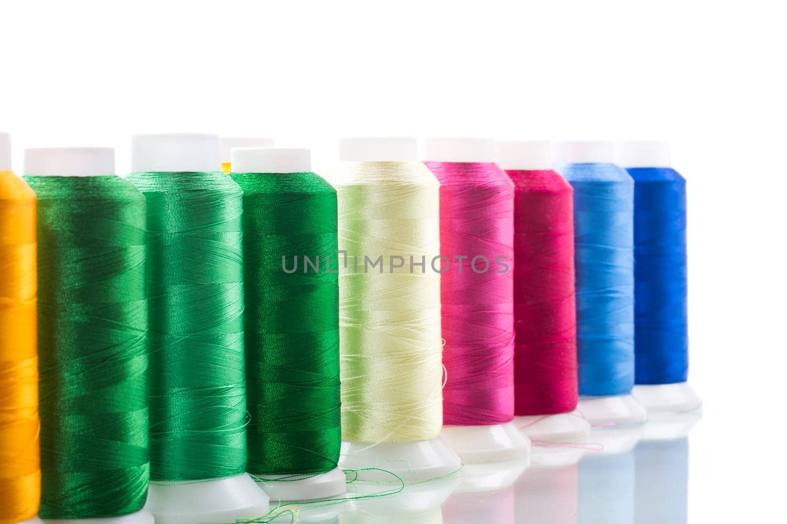 set of different color sewing threads,on white background. by Rawlik