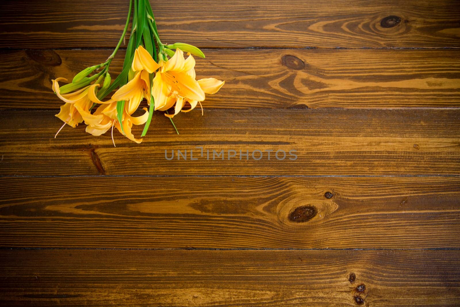 bouquet of beautiful yellow lilies on a dark wooden table