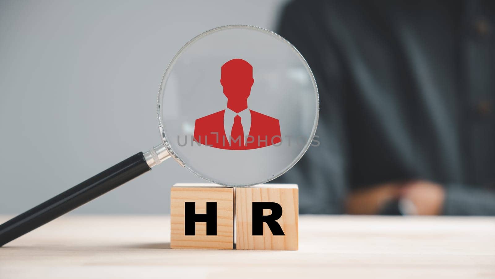 HRM insight Magnifier glass zooms in on manager icon in staff icons, representing the valuable role of human resource management in recruitment, leadership, and customer targeting. employees selection