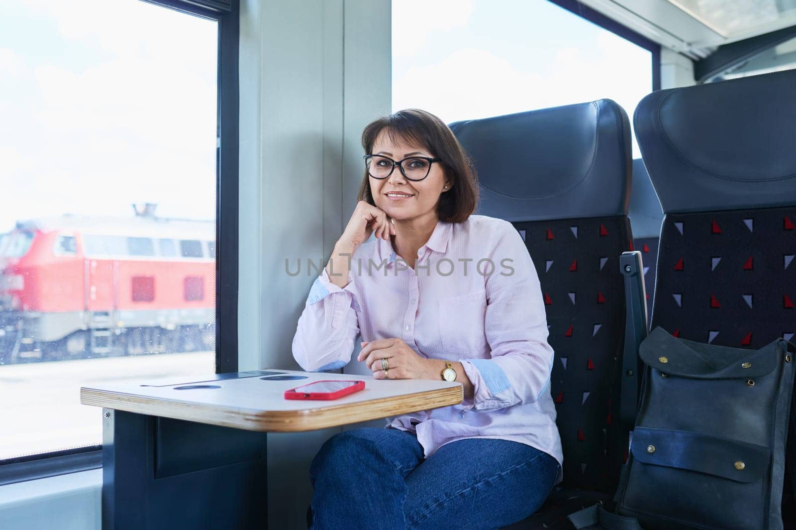 Woman is passenger sitting inside an electric train by VH-studio