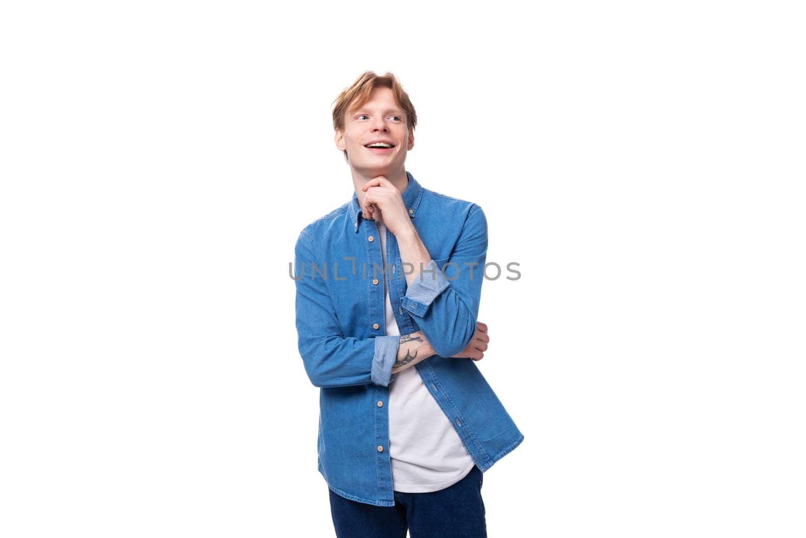 young authentic caucasian man with golden red hair dressed in a blue shirt.