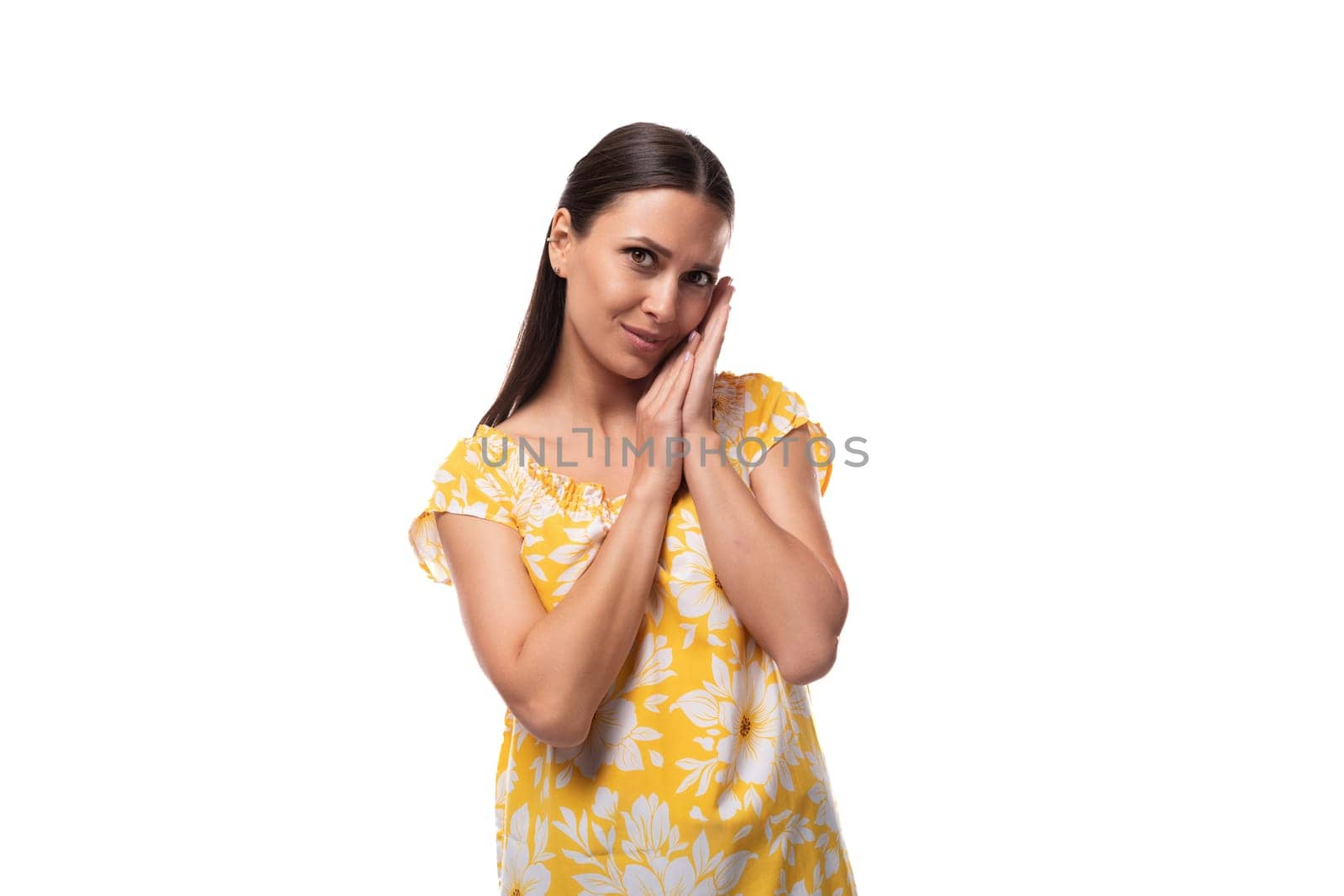 caucasian pleasant cute young woman with straight black hair dressed in a yellow sundress.