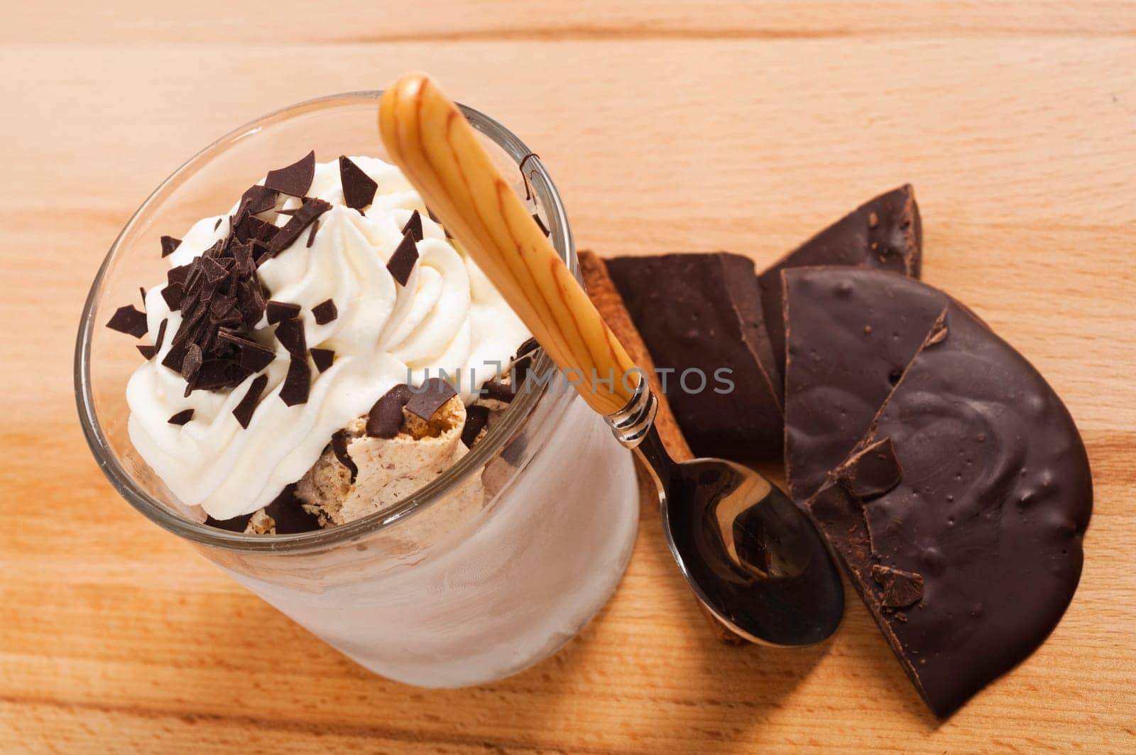 Ice cream dessert in a glass with chocolate and cream topping