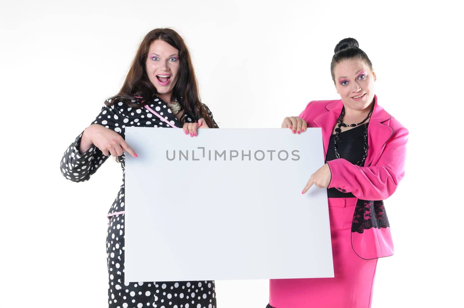 Two attractive plus-size models to wear flashy costumes and presenting a blank billboard, isolated against white background.