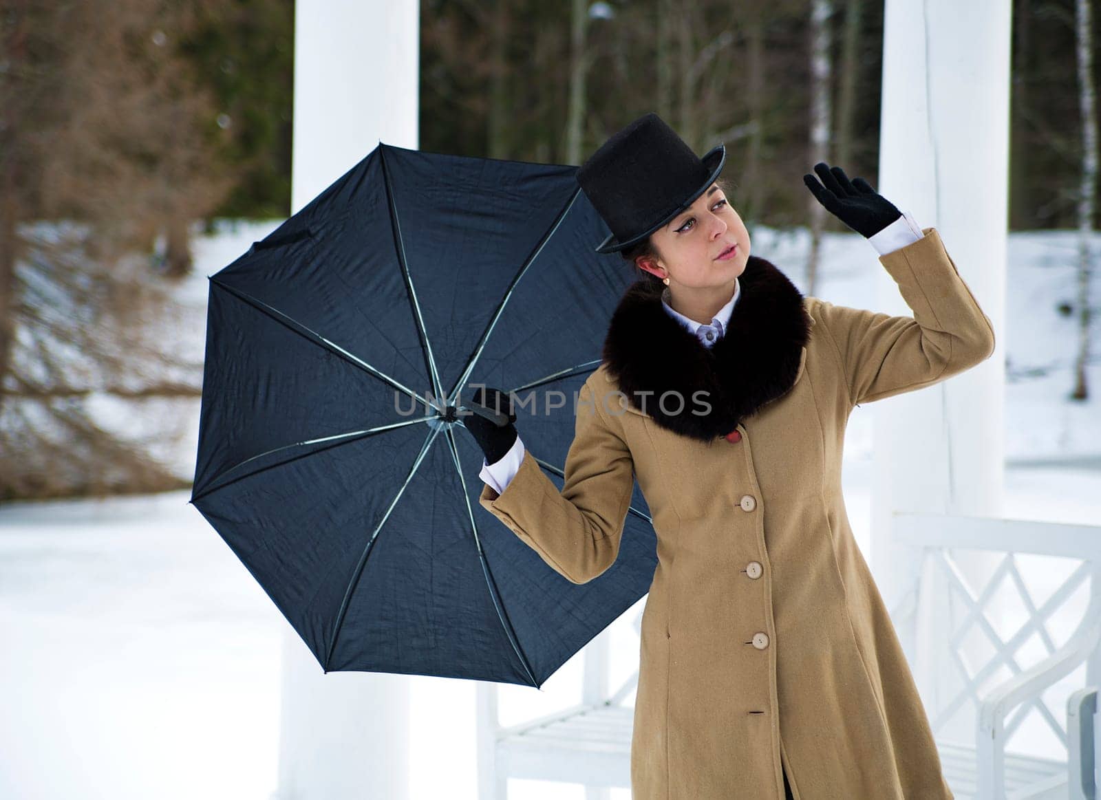 Woman with black umbrella feeling winter wind flow