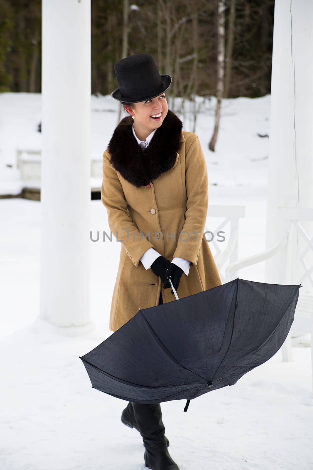 Young woman try close black umbrella on walk