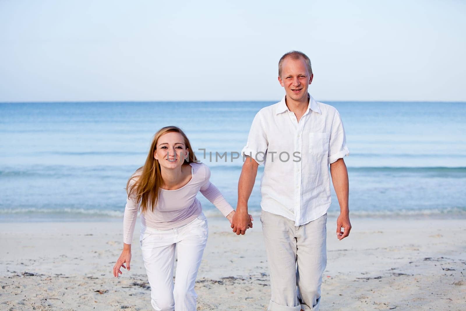 Young happy couple in love having fun on the beach in summer