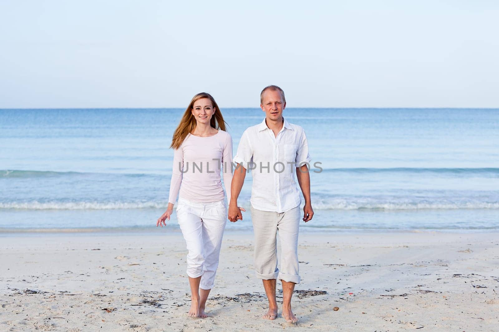 Young happy couple in love having fun on the beach in summer