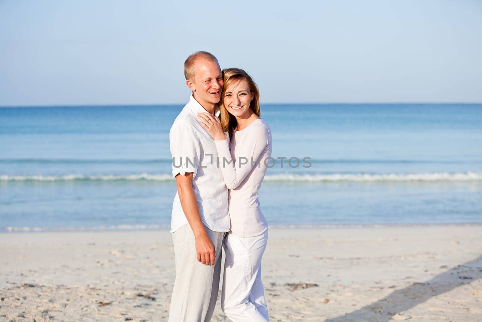Young happy couple in love having fun on the beach in summer