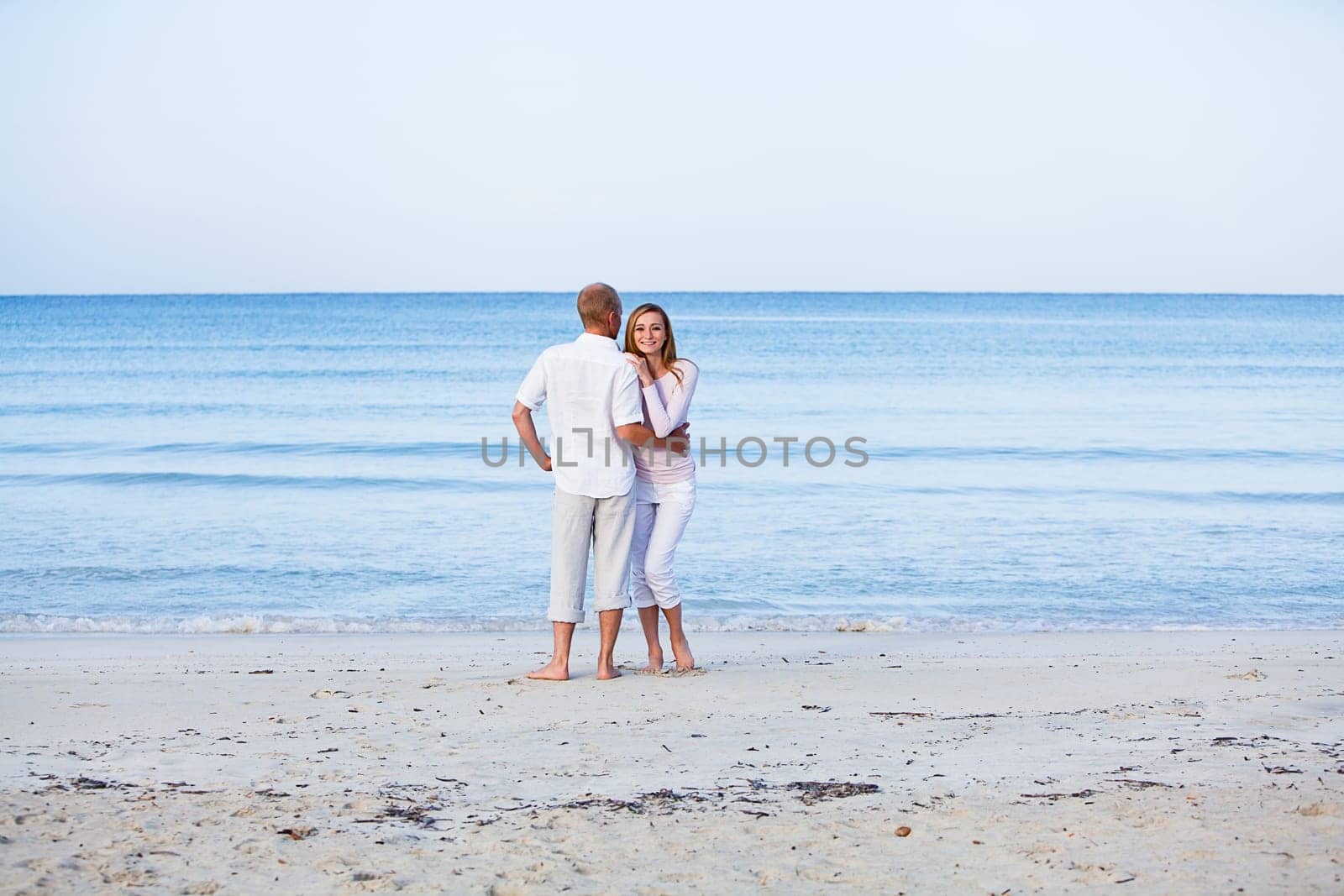 Young happy couple in love having fun on the beach in summer