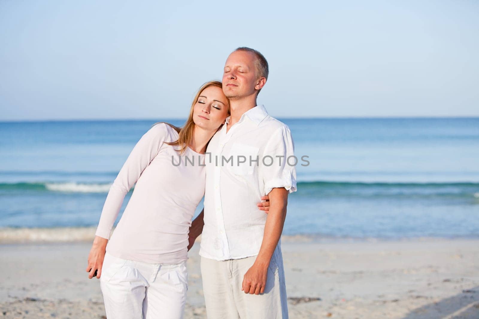 Young happy couple in love having fun on the beach in summer