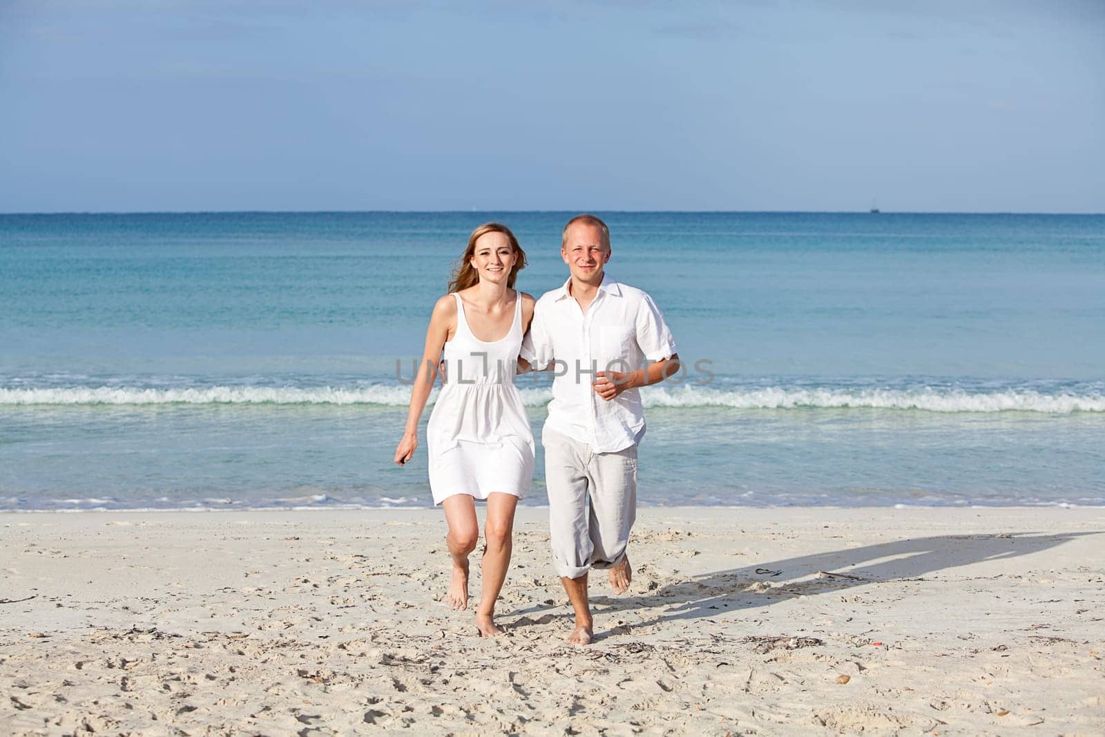Young happy couple in love having fun on the beach in summer