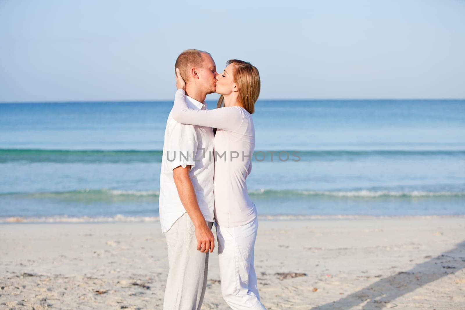 Young happy couple in love having fun on the beach in summer