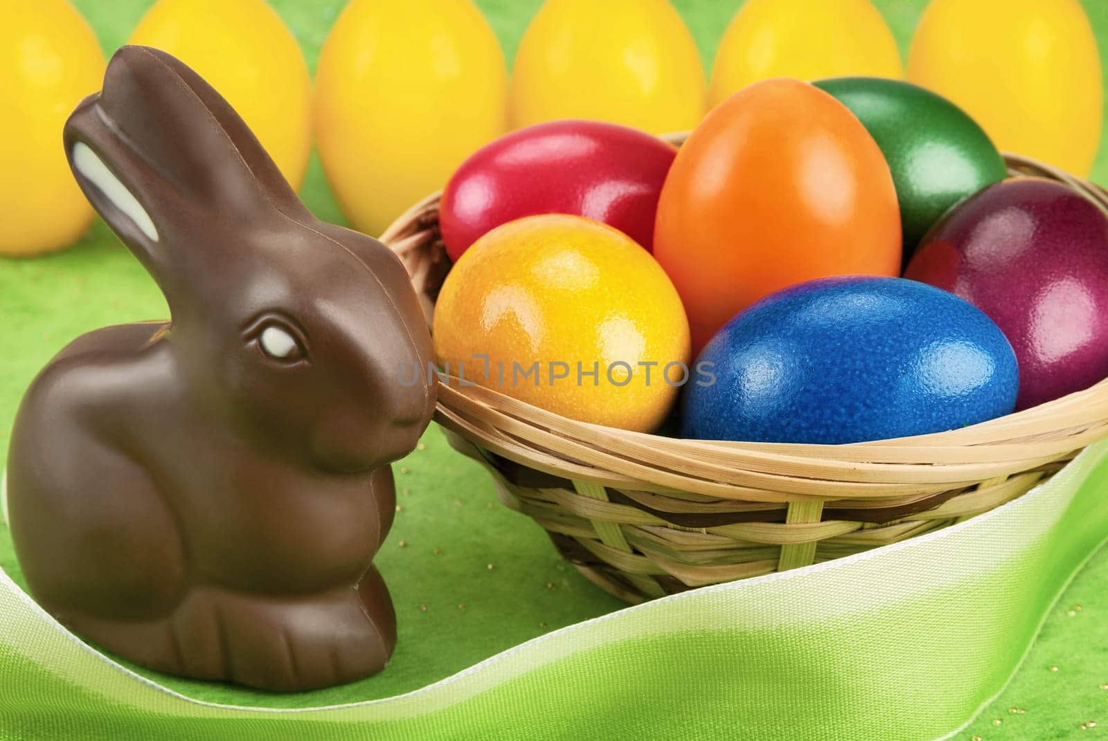 Chocolate Easter bunny and painted Easter eggs in a basket