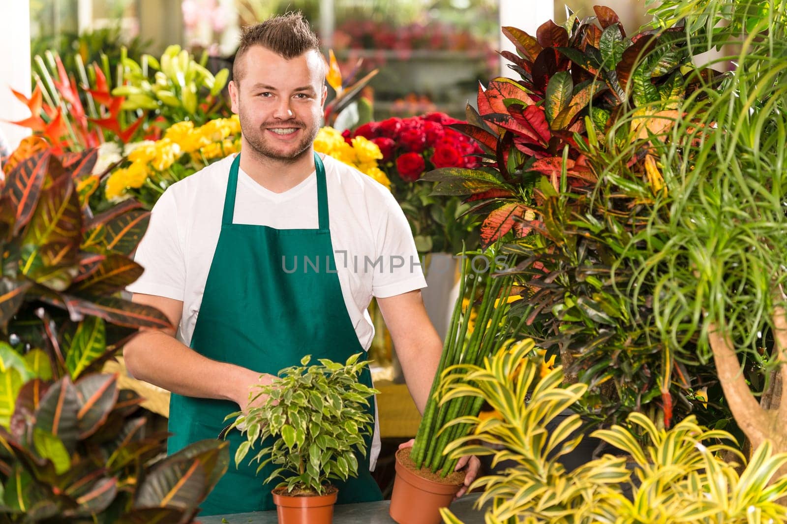 Happy male florist working flower gardening shop market assistant
