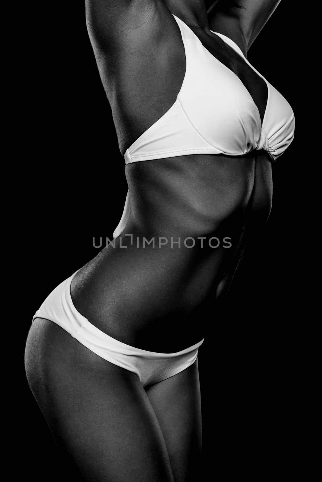 Young woman with white bikini against black background