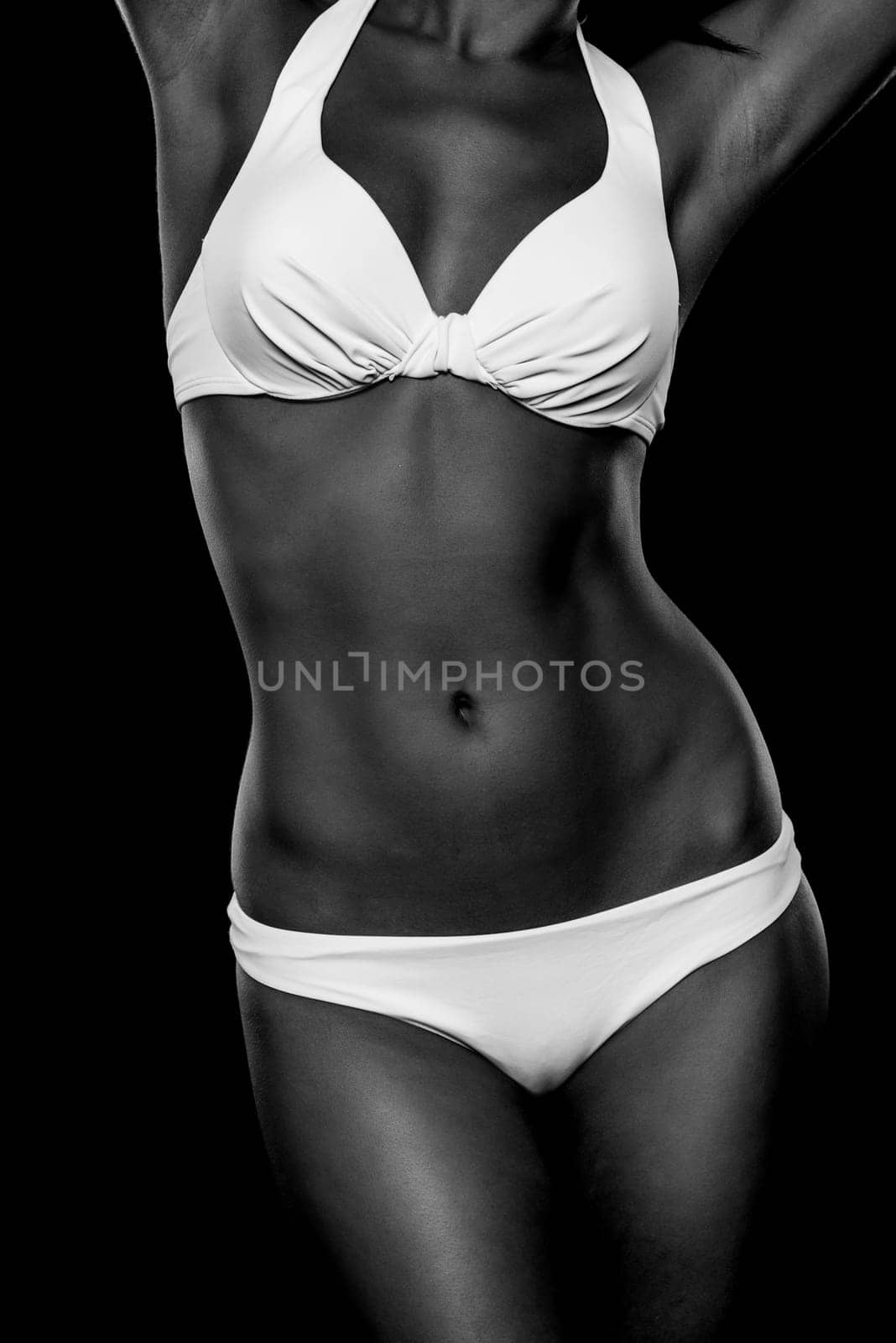 Young woman with white bikini against black background