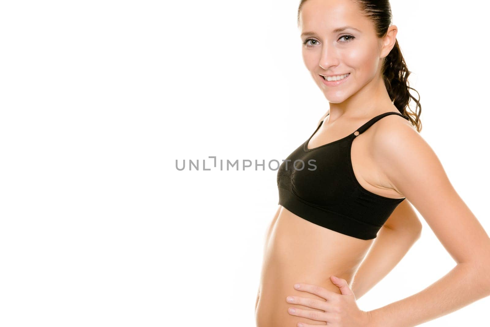 Young woman in sporty outfit against white background