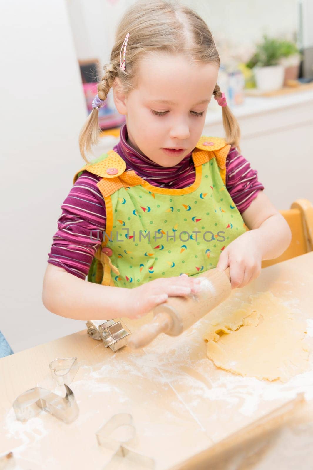 Little girl baking cookies in the kitchen