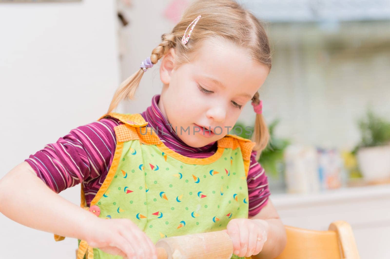 Little girl baking cookies in the kitchen