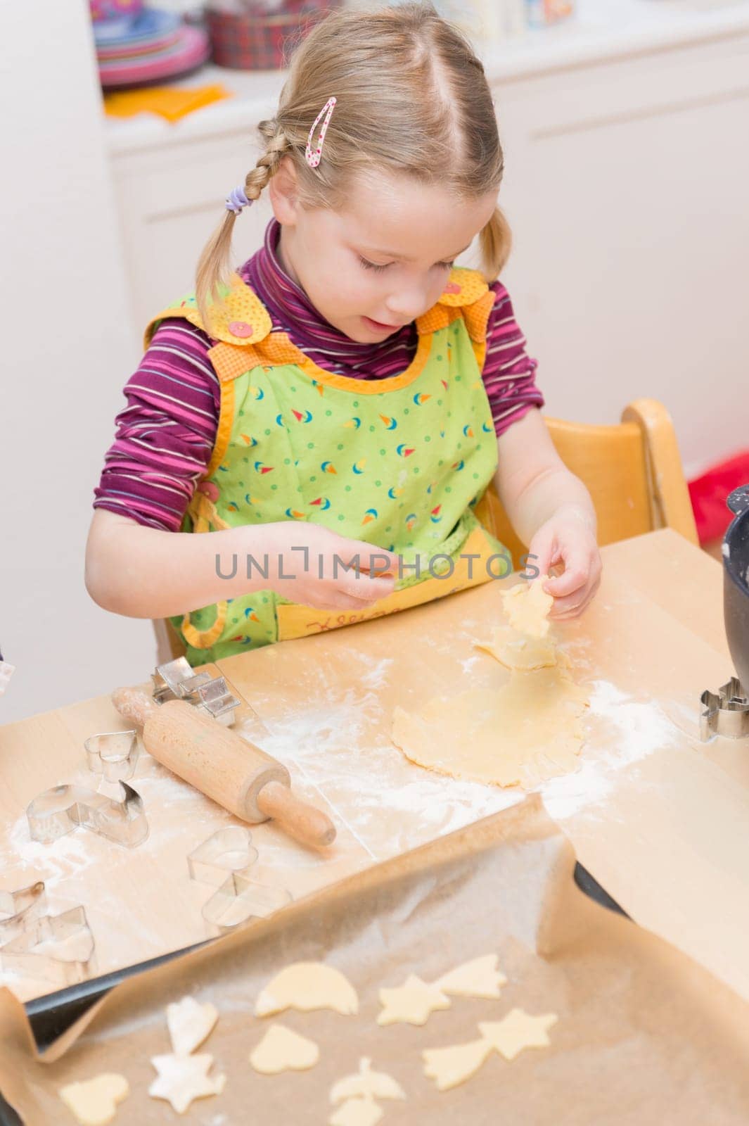 Little girl baking cookies in the kitchen