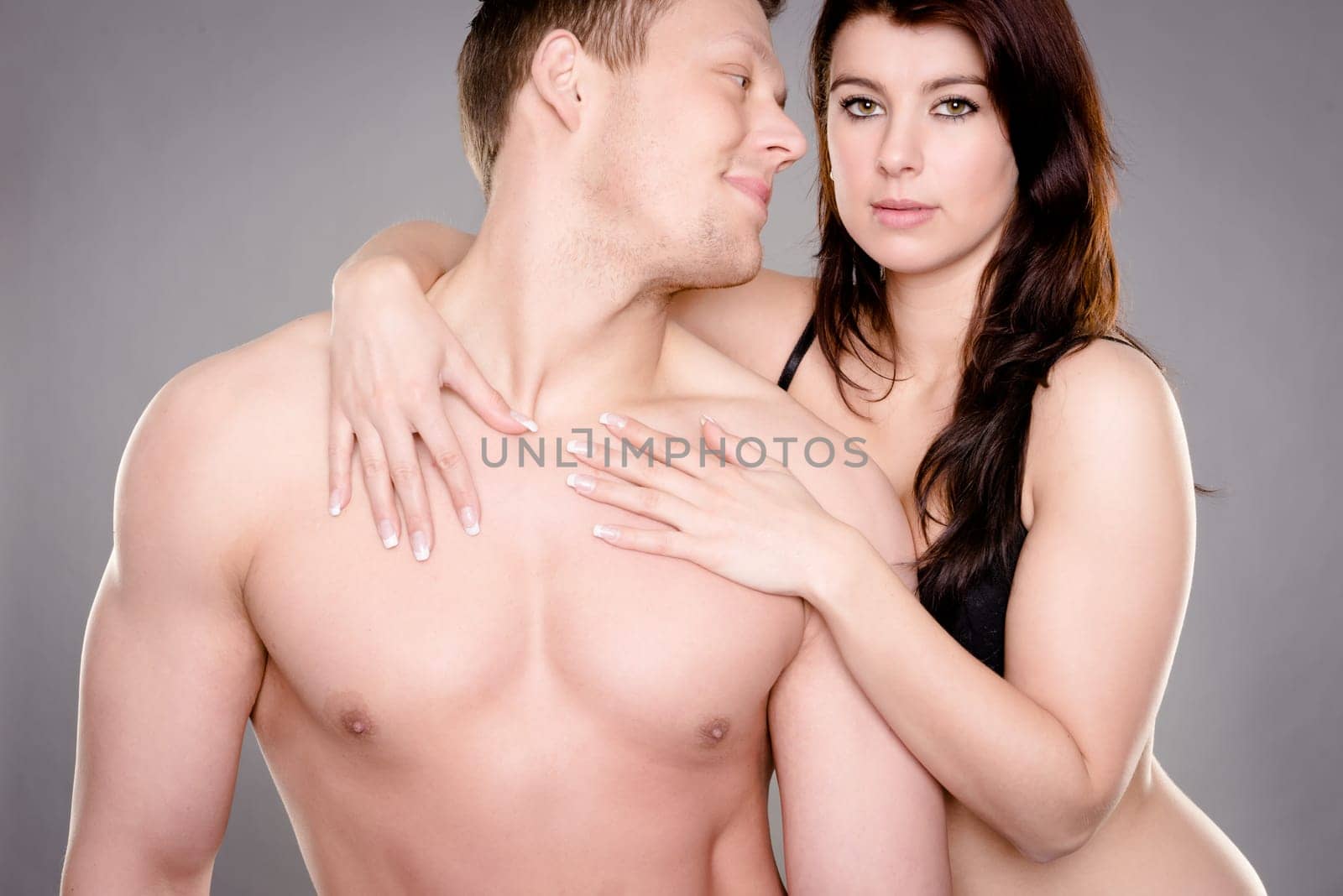 Studio shot of a young couple against a gray background