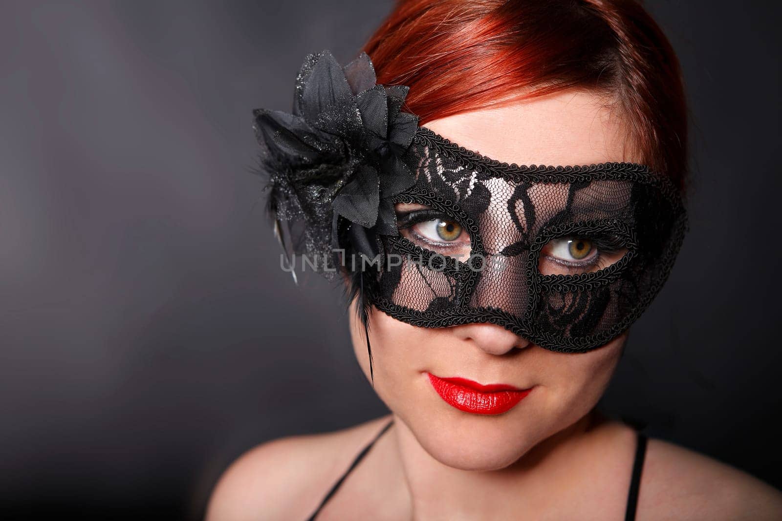 Young woman with black carnival mask