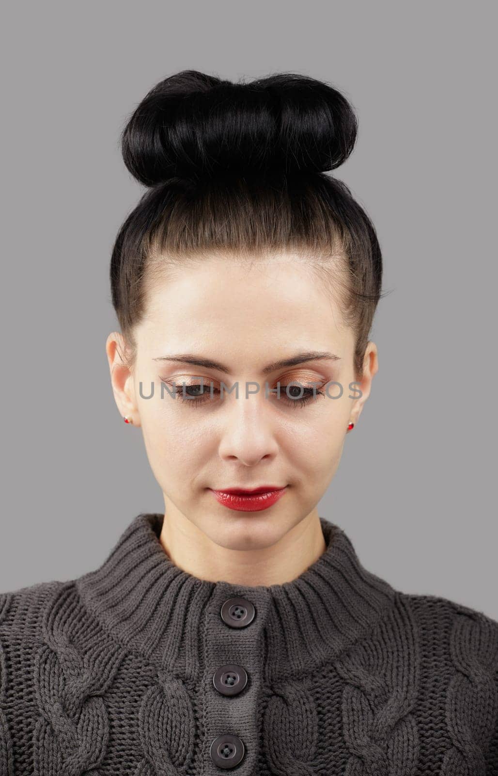 Portrait of a beautiful young woman over grey background.