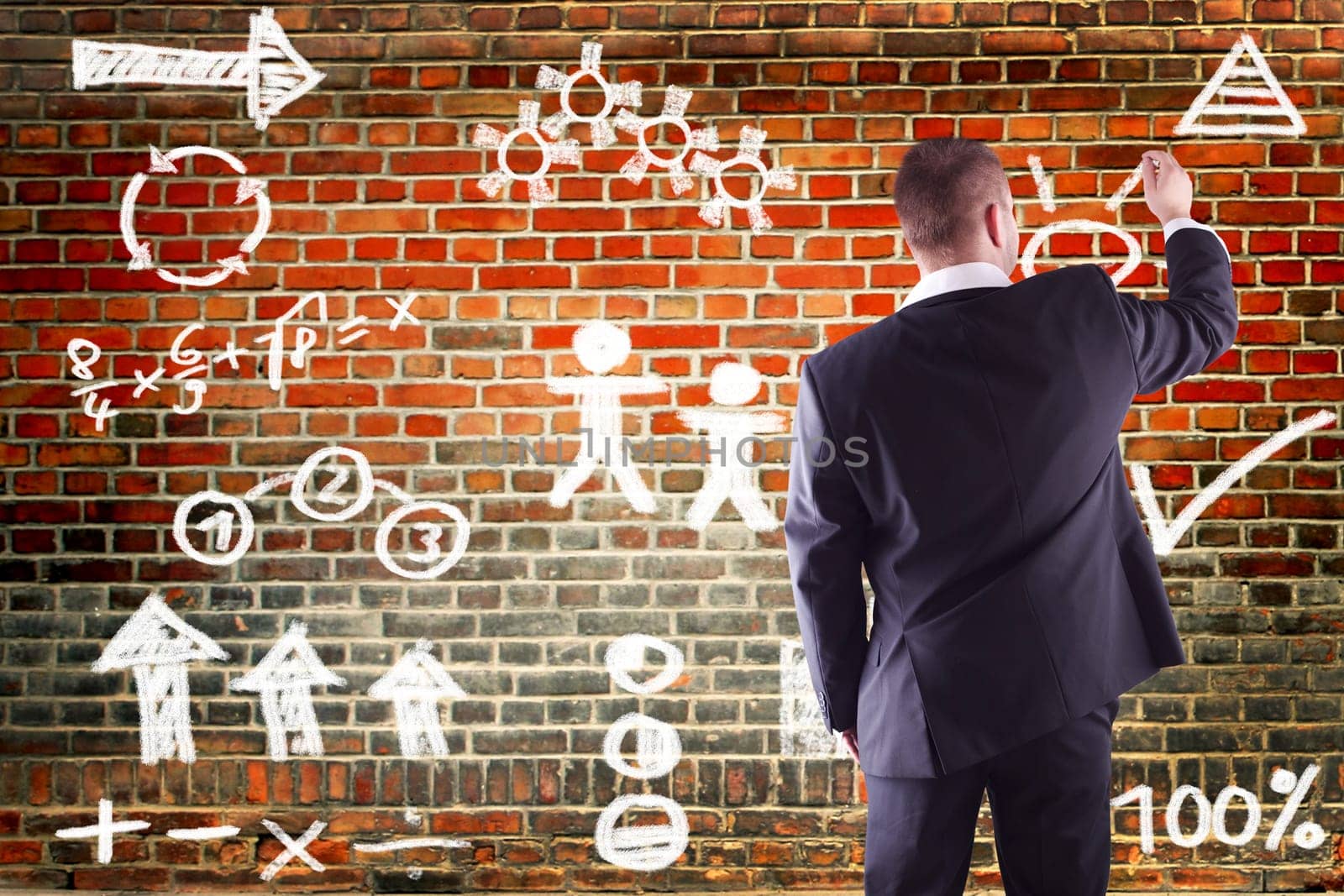 Businessman writing business plan to wall