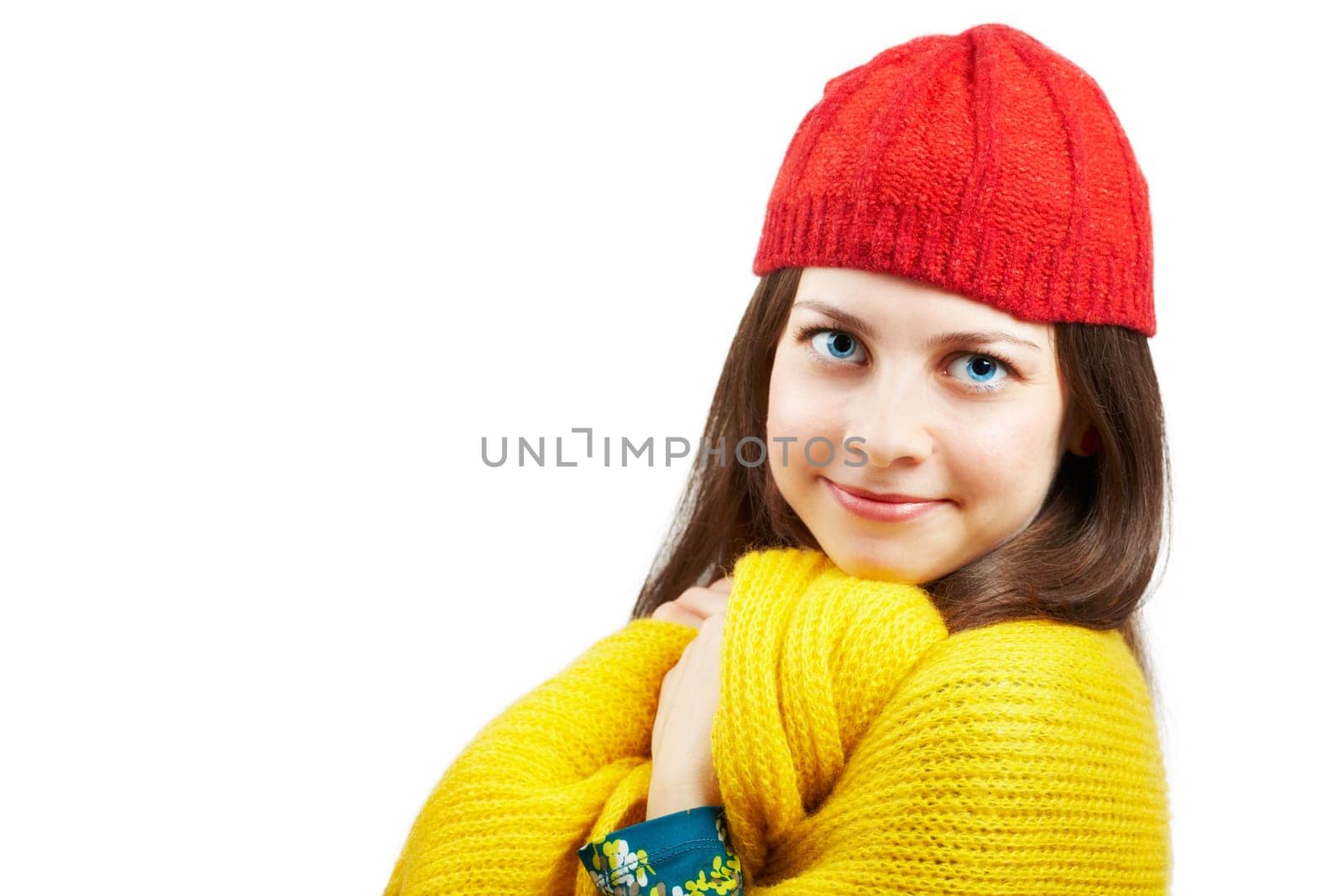 Portrait of a beautiful young woman with yellow scarf and red hat over white background.