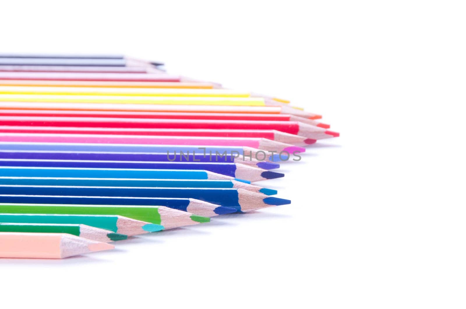 Shot of multicolored pencils in row isolated on white