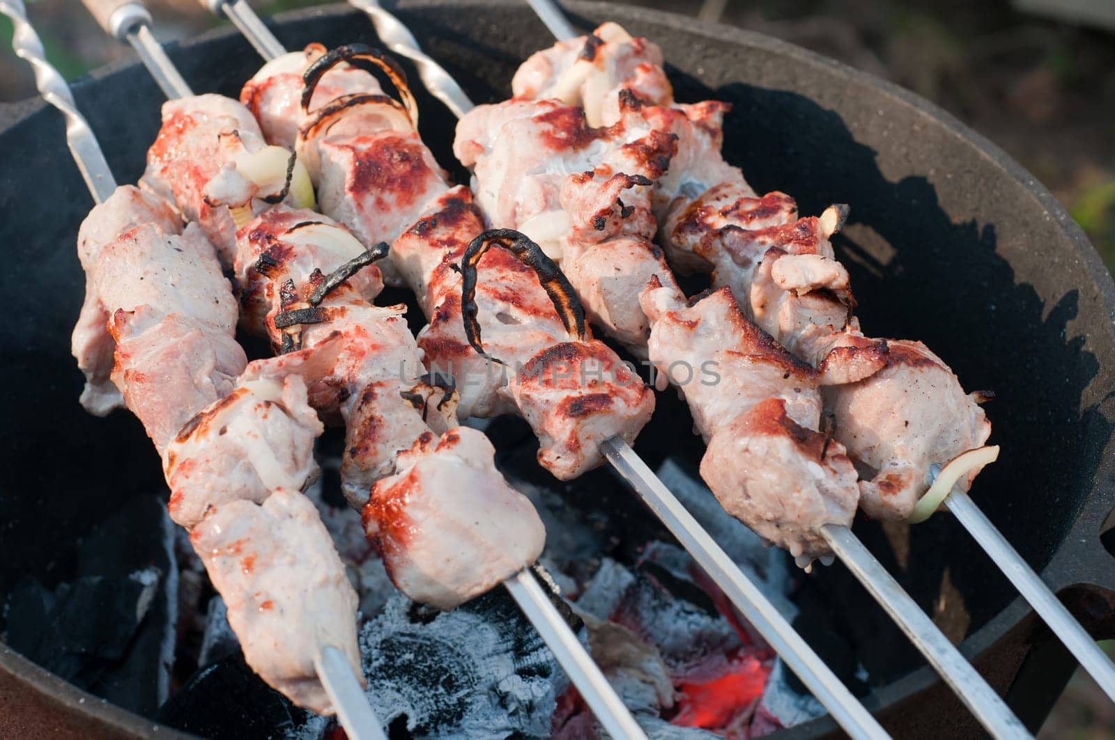 Shish kebab preparation on a brazier, outdoor picnic