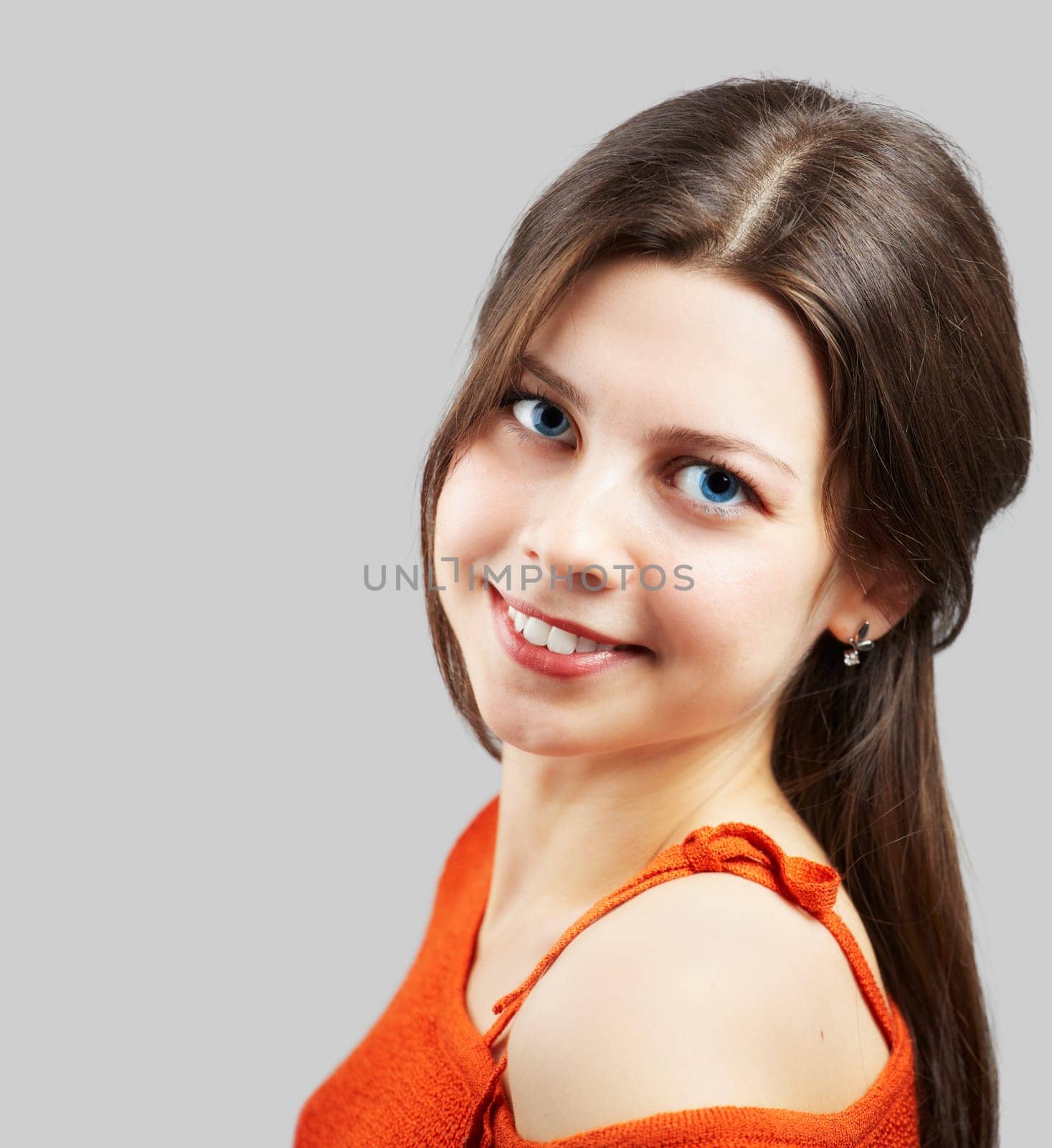 Portrait of a beautiful young woman with red top over grey.