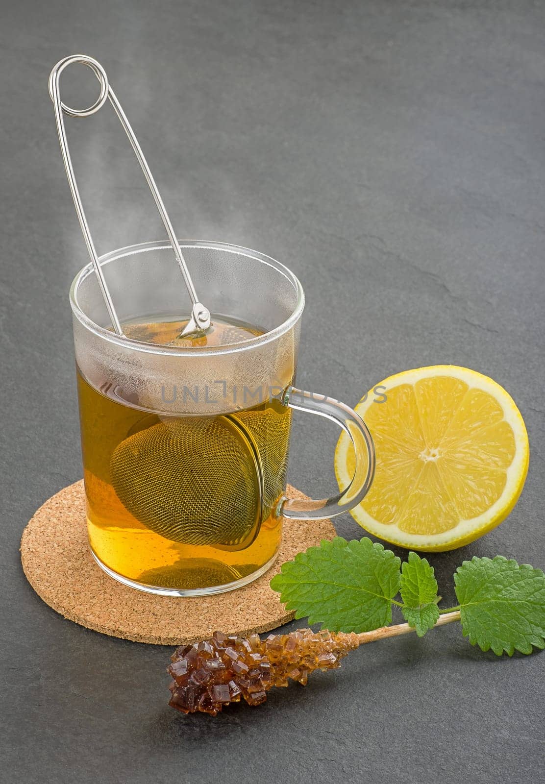 Steaming tea cup with strainer on slate plate